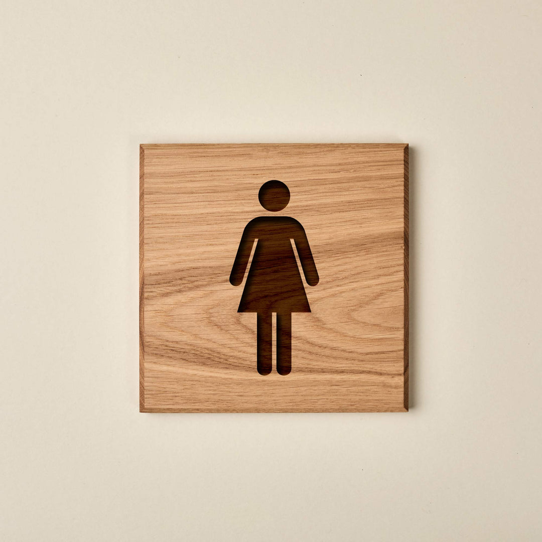 Square oak ladies's restroom sign featuring an engraved female silhouette. The sign has a warm, natural wood finish and a prominent grain.