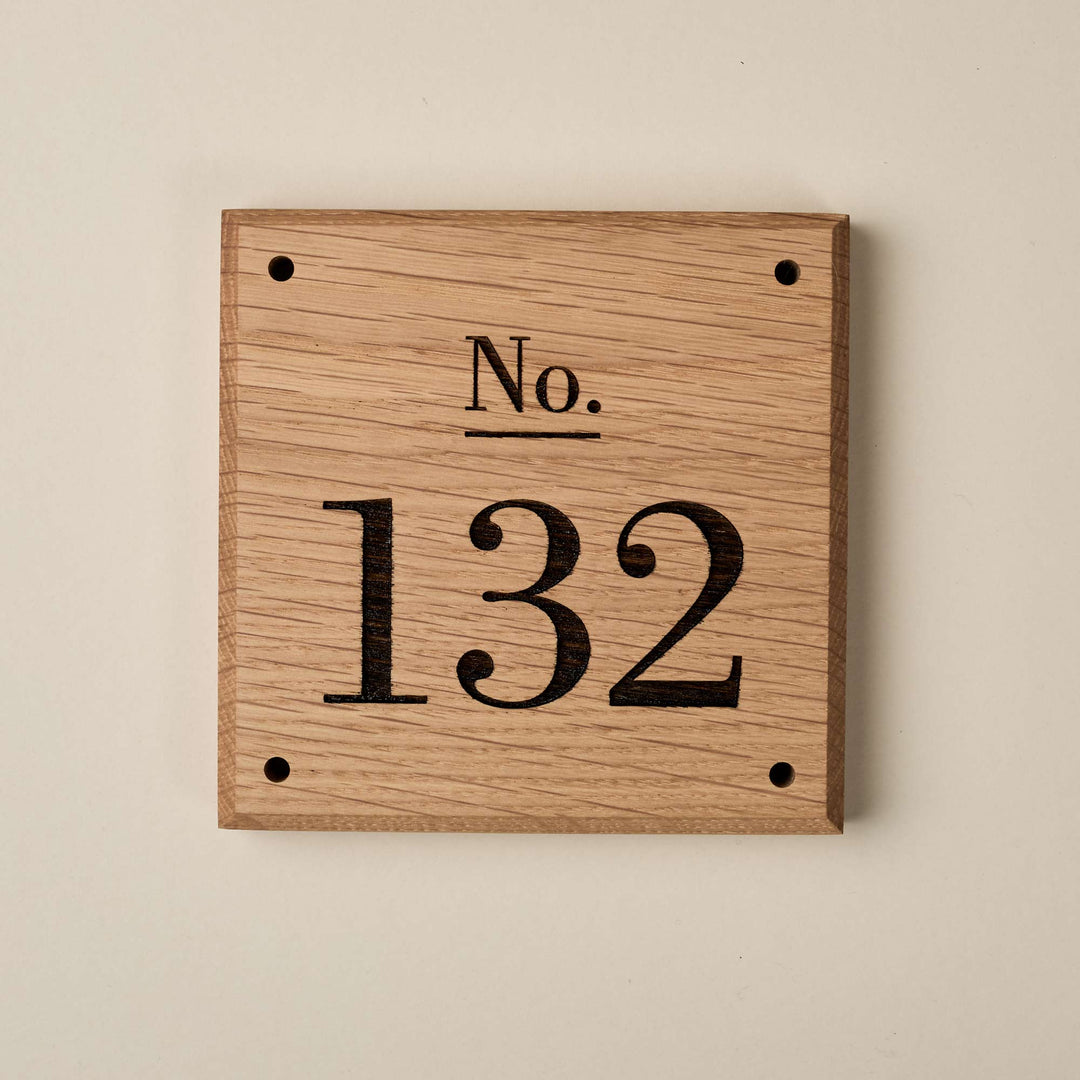Wooden Victorian Oak House Number Sign in a front-facing studio view against a plain background, showing the engraved serif numbering '132', bevelled edge finish, screw holes and natural grain.