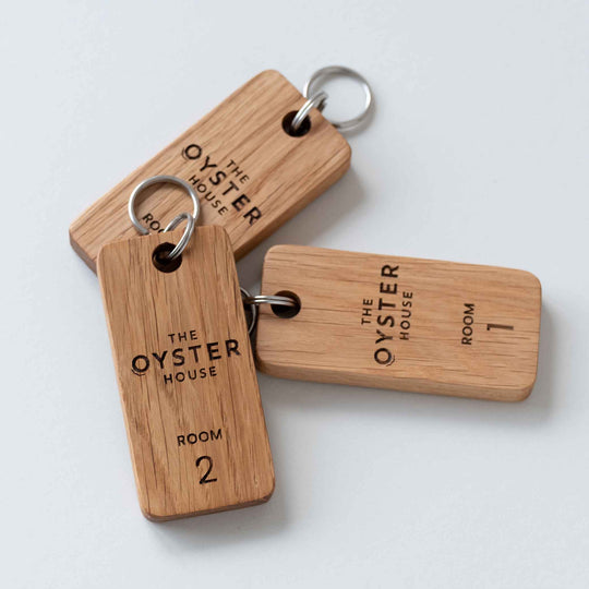 Three Oak keyrings engraved with The Oyster House and Room Numbers 1 & 2